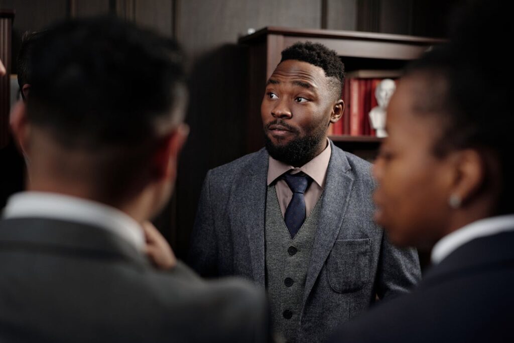 Group of business professionals in discussion inside an office setting.